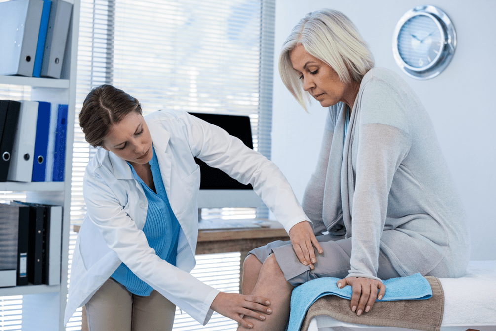 A patient with arthrosis who needs therapy being examined by a doctor